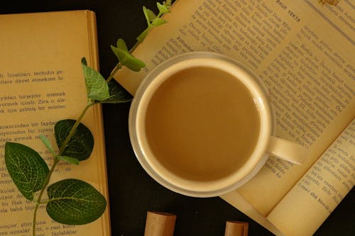 Close-Up Photo of a Cup of Coffee Beside Green Leaves