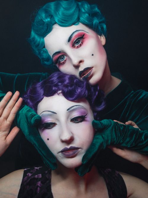 Free Artistic double portrait featuring vivid makeup and retro costumes on a black background. Stock Photo