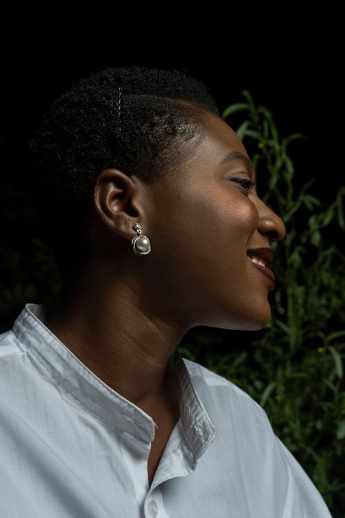 A Woman in White Blouse With Silver Stud Earrings