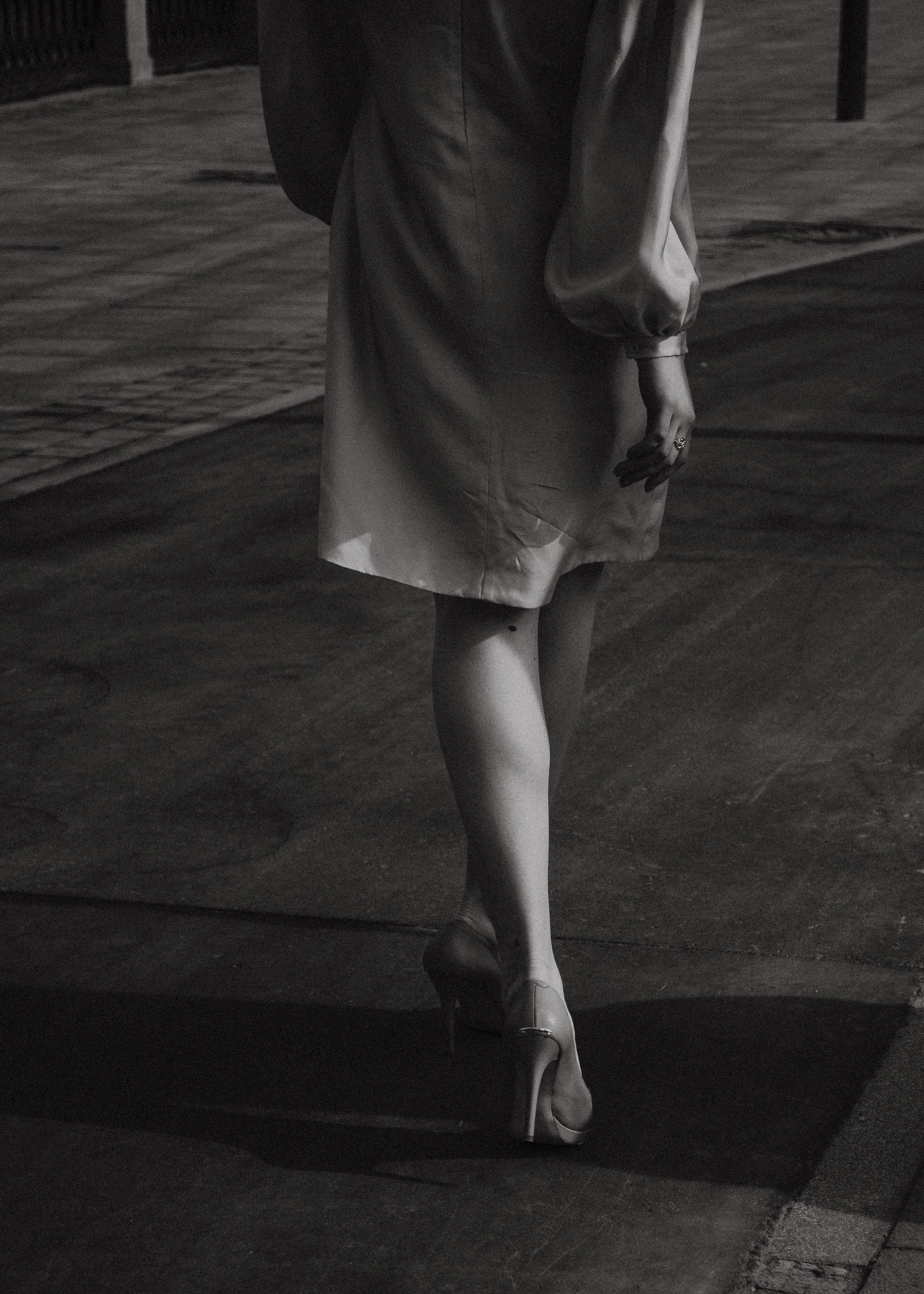 Grayscale Photo of a Woman Walking on Street · Free Stock Photo