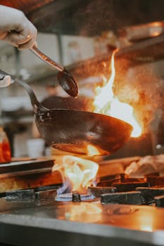 A chef expertly handles a flaming pan in a professional kitchen in Eskişehir, Turkey.