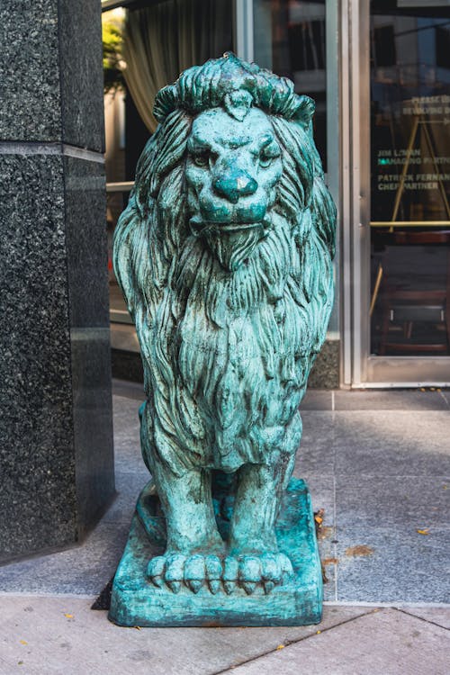 Lion Statue Near Glass Door of a Establishment