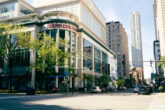 Vibrant cityscape in downtown Chicago with the Grand Lux Cafe and high-rise buildings on a sunny day.