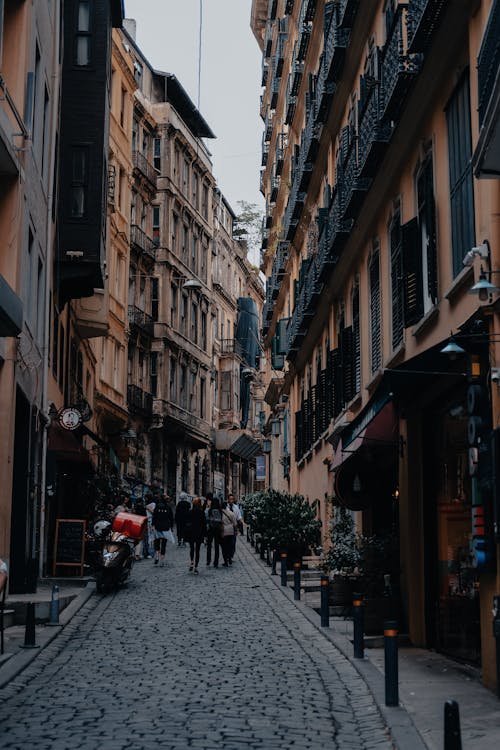 Busy People Walking on the Street Between Buildings