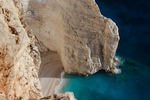 Stunning aerial view of Navagio Beach's iconic cliff and turquoise waters in Zakynthos, Greece.