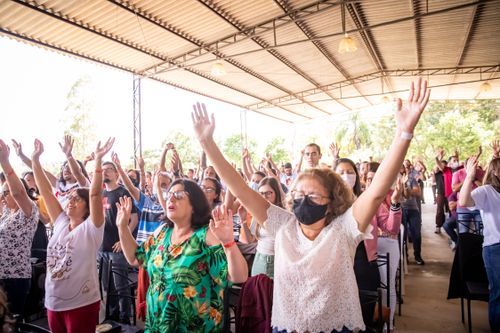Free People with raised arms celebrate at a lively outdoor event filled with joy and energy. Stock Photo