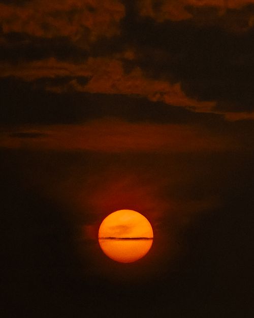Free Capture of a dramatic sunset with a vivid orange sky and clouds over India. Stock Photo