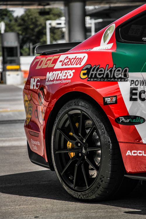 Free Vibrant detailed shot of a sports car showing logos and a sleek tire design. Stock Photo