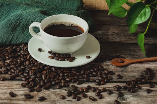 Warm rustic scene of a coffee cup on wooden table with scattered beans.