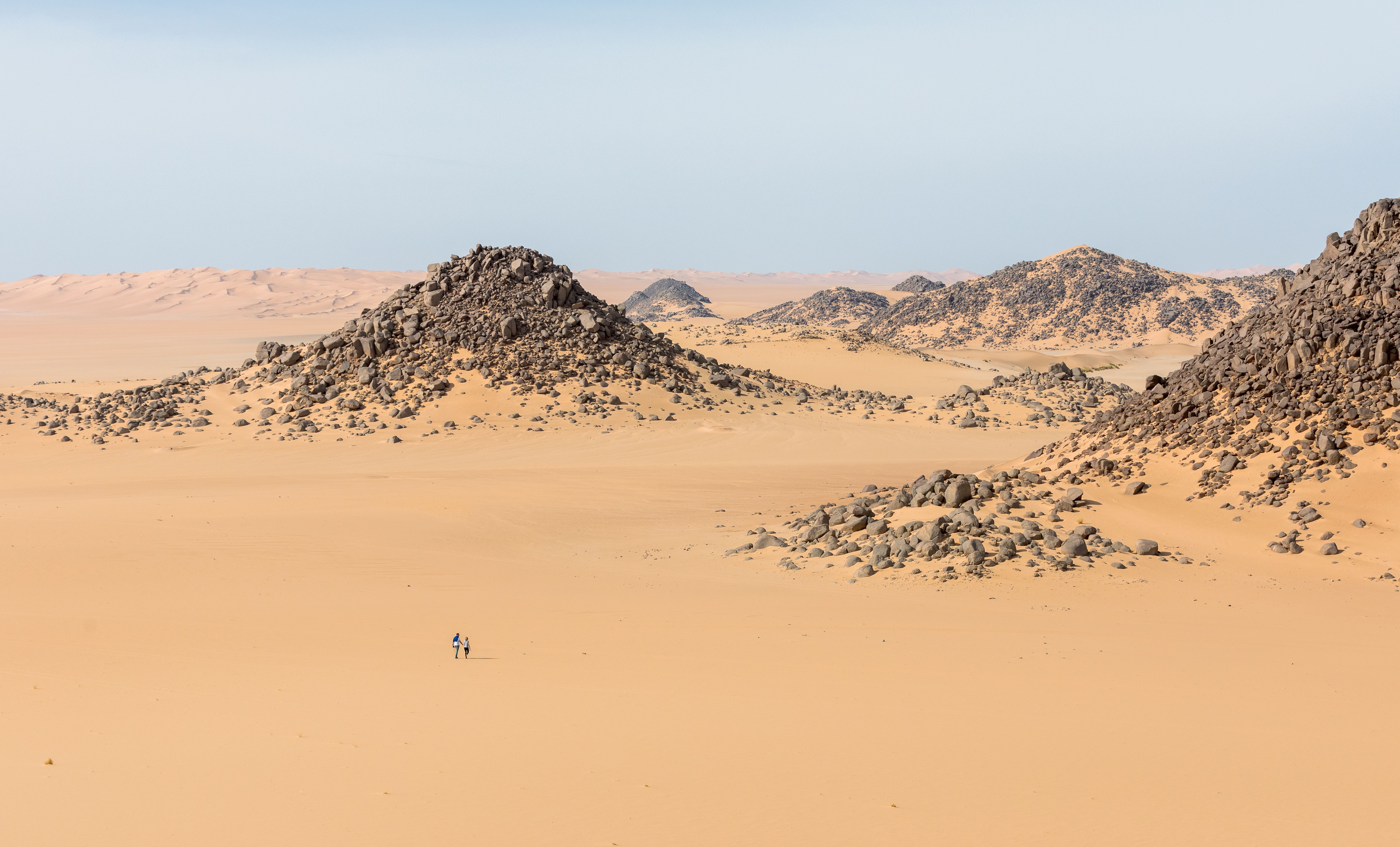 Expansive desert scene with rocky formations in Illizi, Algeria, showcasing the barren beauty of the Sahara.