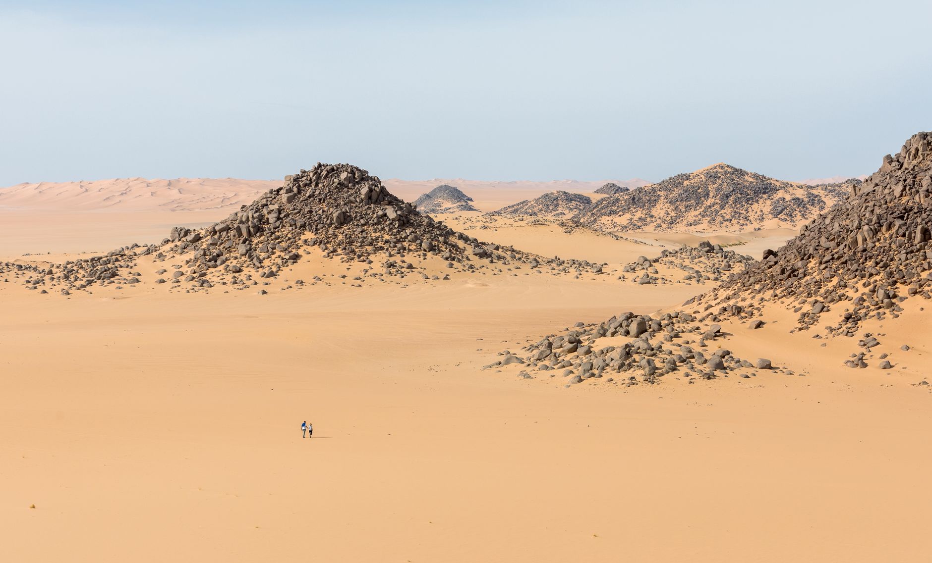 Expansive desert scene with rocky formations in Illizi, Algeria, showcasing the barren beauty of the Sahara.