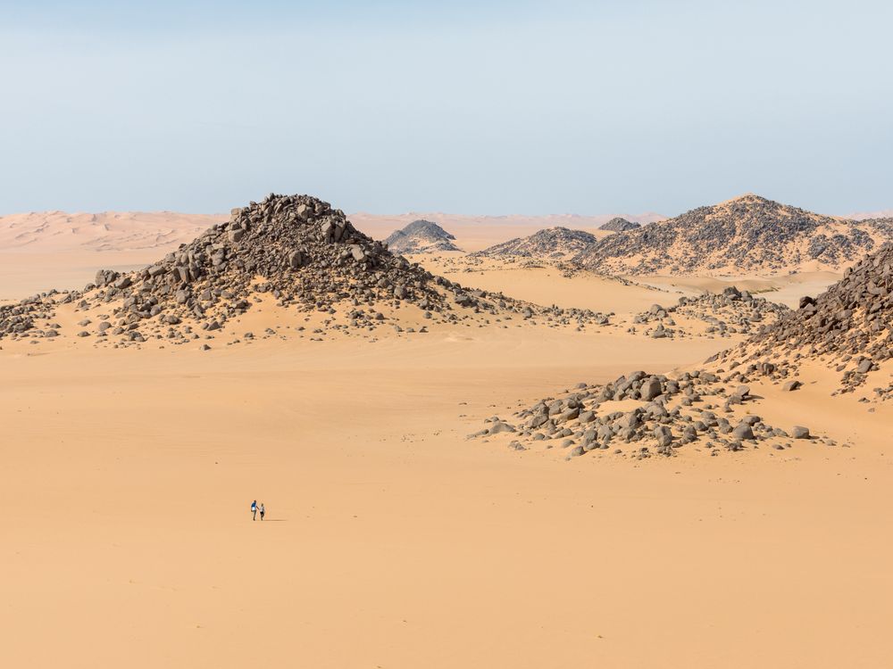 Piles of rocks in sandy desert, Algeria