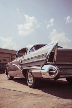 Classic Buick Roadmaster captured on a sunny day showcasing its vintage tail fins and chrome details.