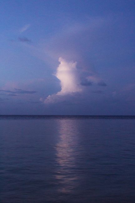 Peaceful seascape at dusk with a striking cloud formation reflecting on the ocean.