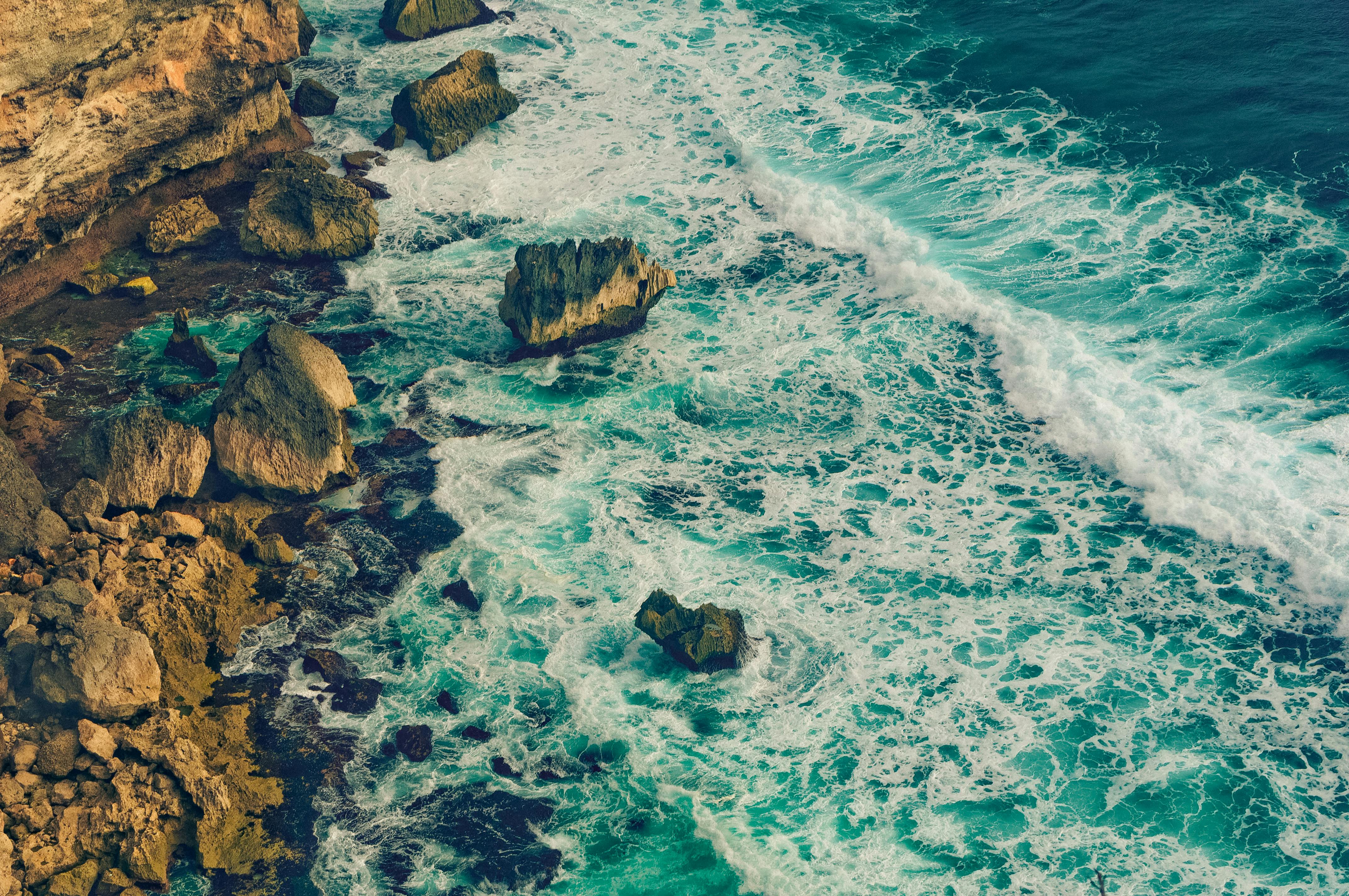 brown rock formation on body of water