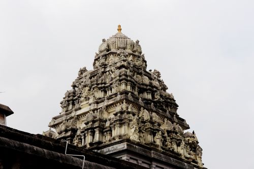 Free Low-angle view of the Ekambareswarar Temple's ornate top against a cloudy sky. Stock Photo