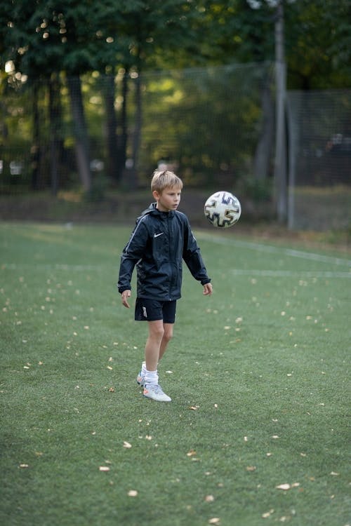 Boy Wearing Jacket Playing Soccer