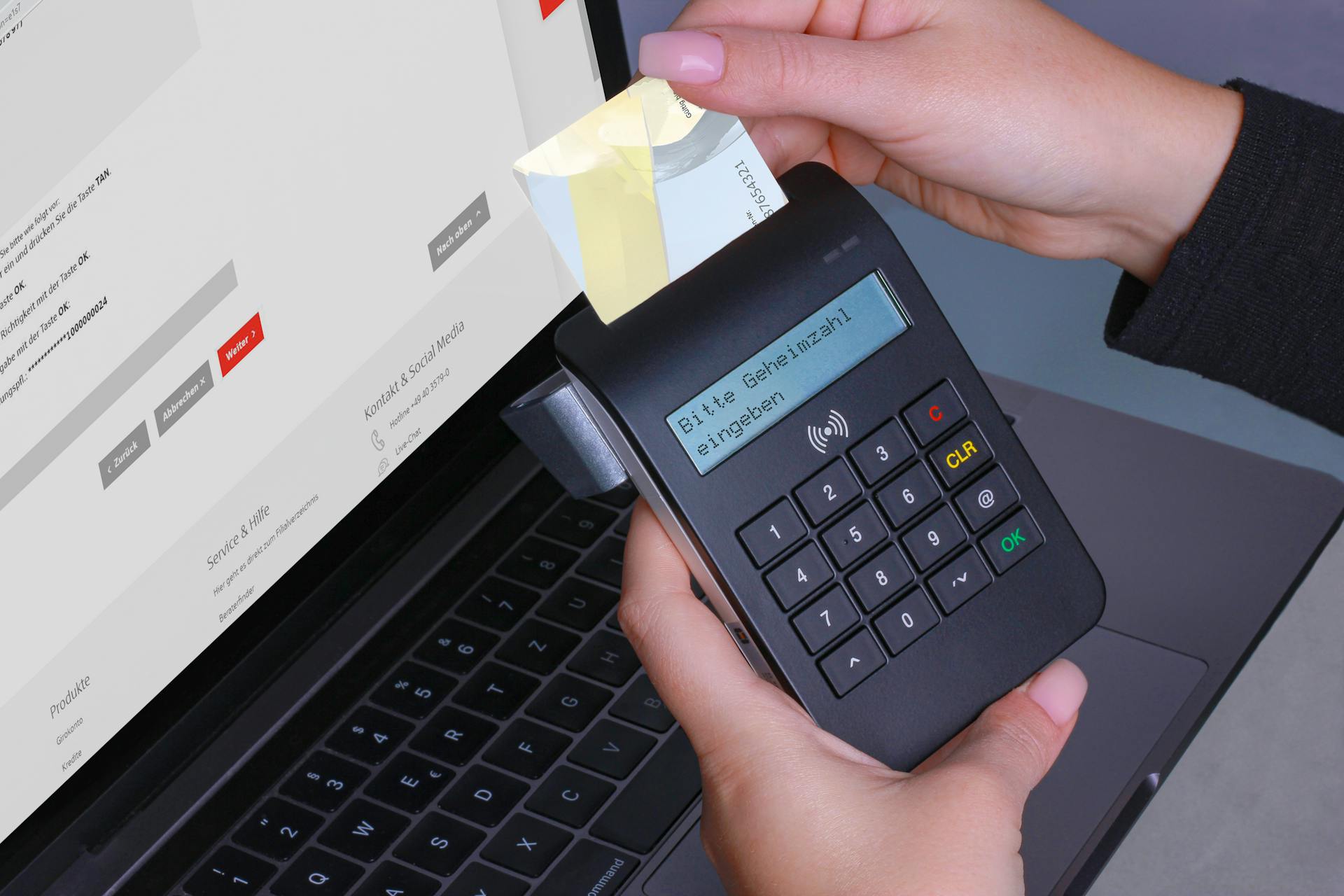 A person using a card reader for a secure online payment with a laptop and PIN entry.