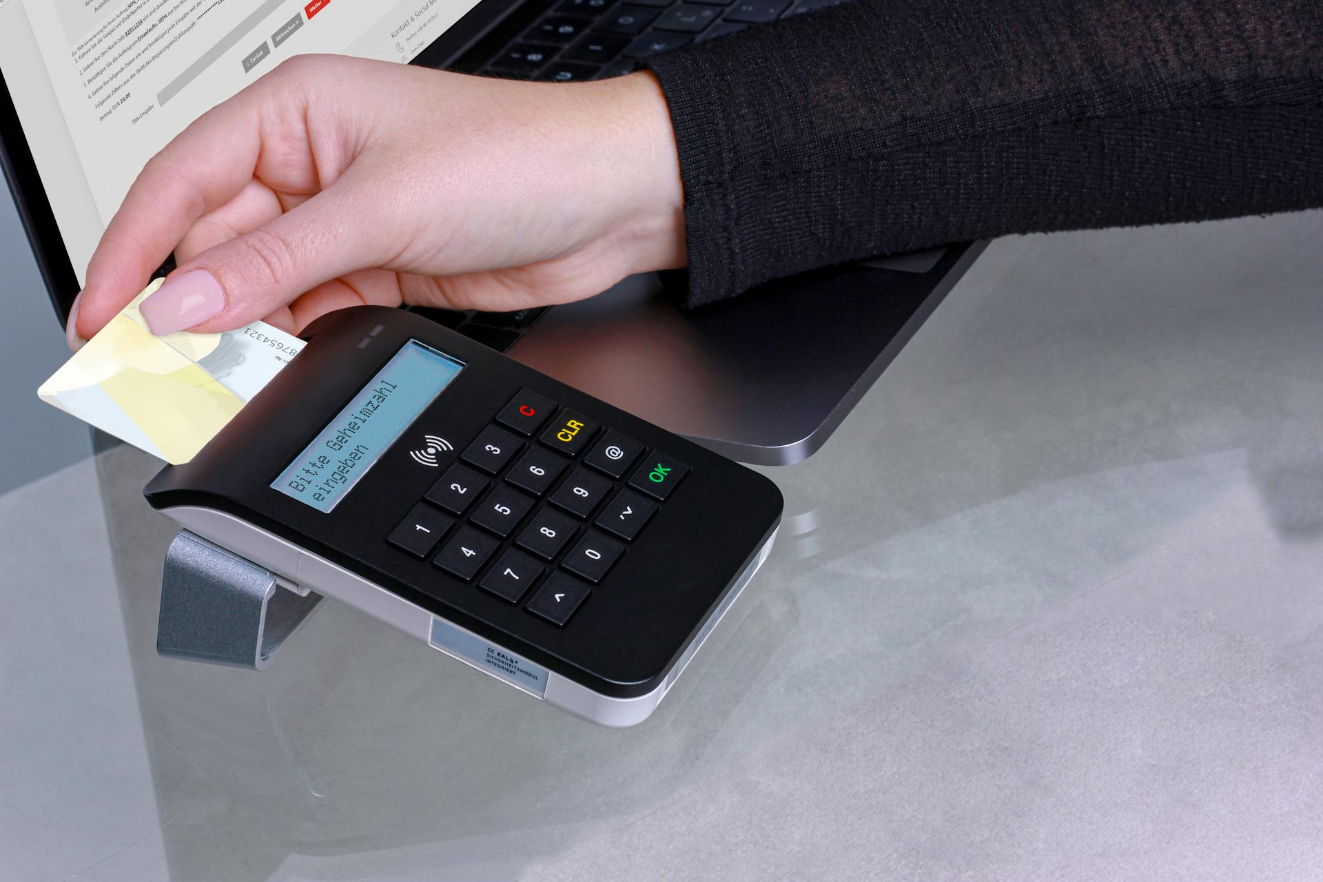 Hand inserting card into contactless payment terminal for secure online transaction.