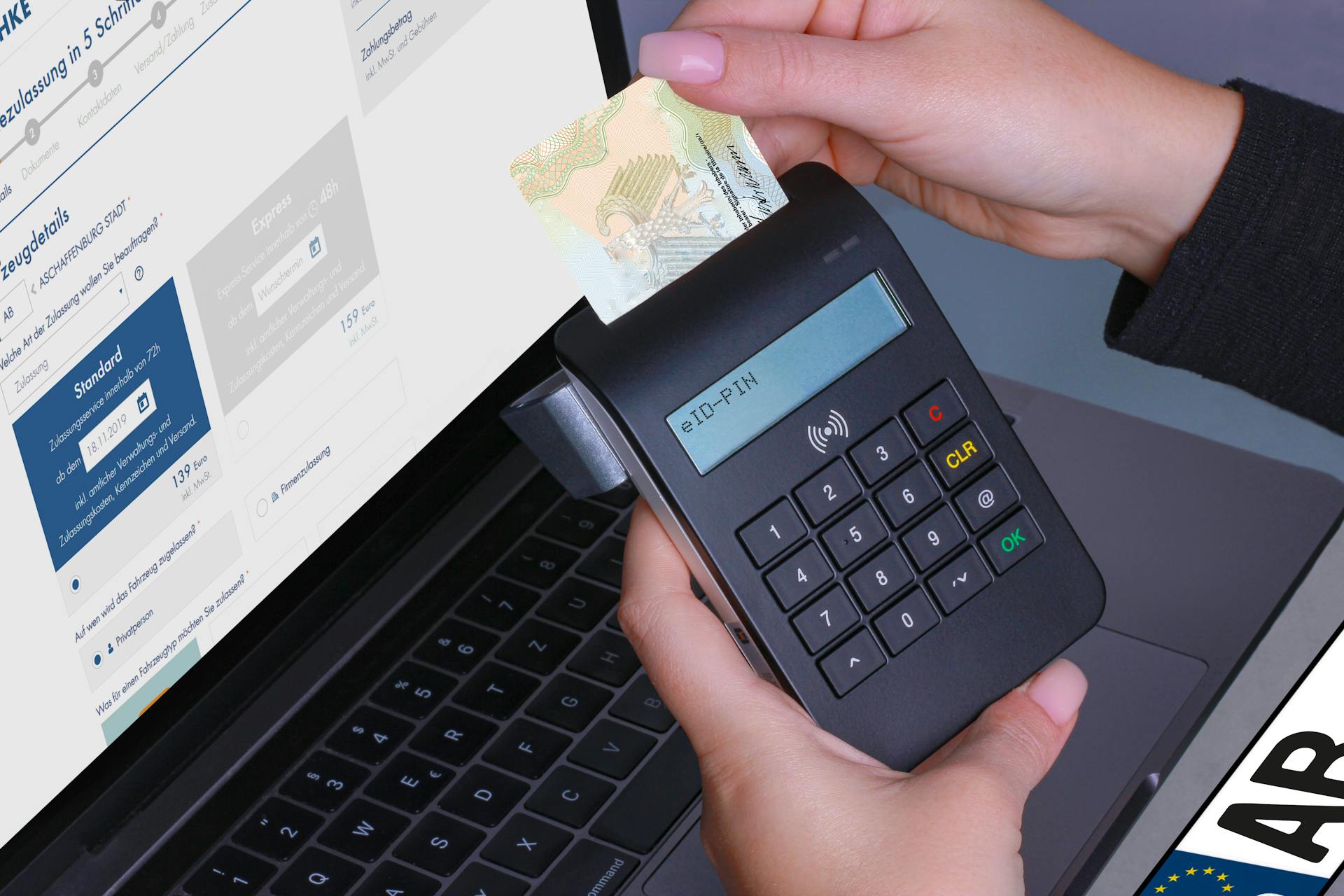 Close-up of a contactless payment using a card reader and laptop, highlighting digital security.