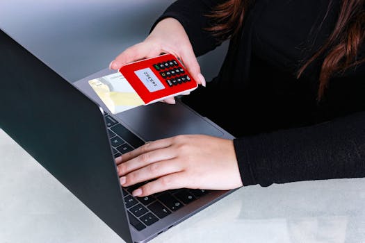 online identity verification error - Close-up of hands using a credit card and laptop for online payment at a desk.