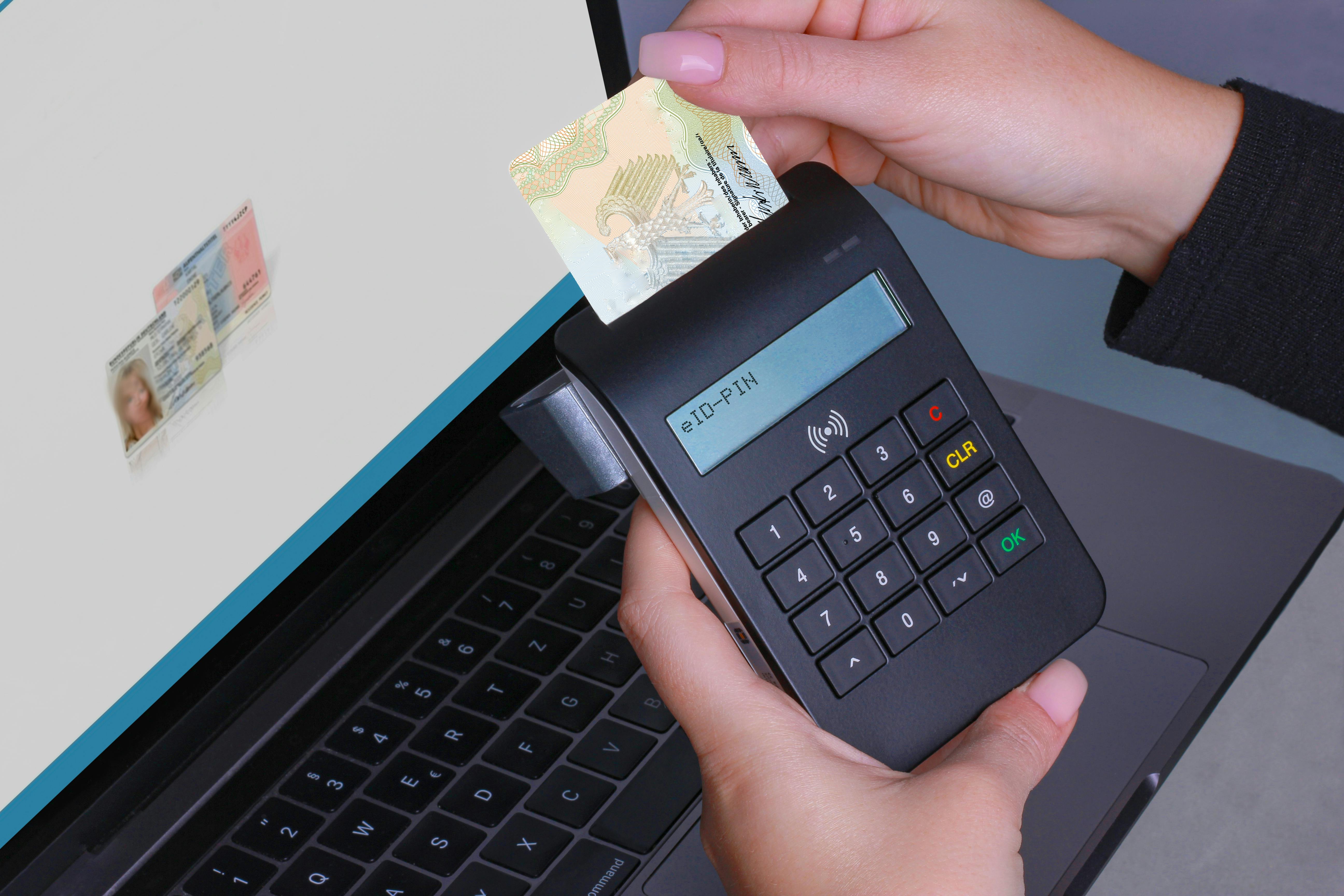 Person using contactless device for ID payment verification on a laptop.