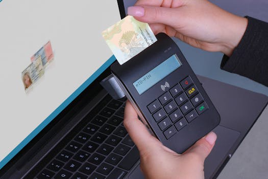 Person using contactless device for ID payment verification on a laptop.