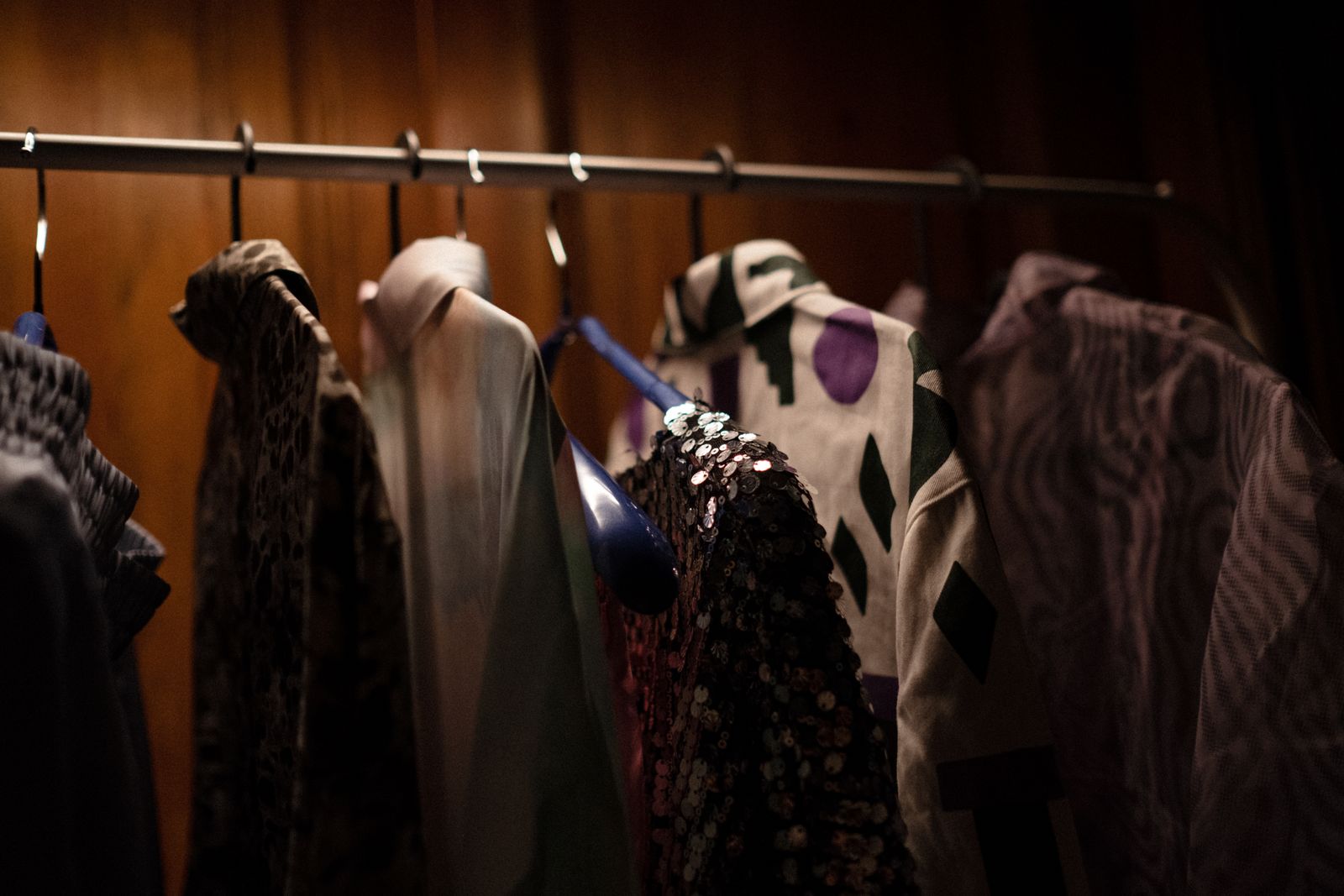 Organized wardrobe with shirts and blouses hanging neatly without people