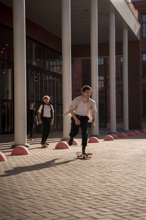 Free Young men skateboarding near modern architectural building during daytime. Stock Photo