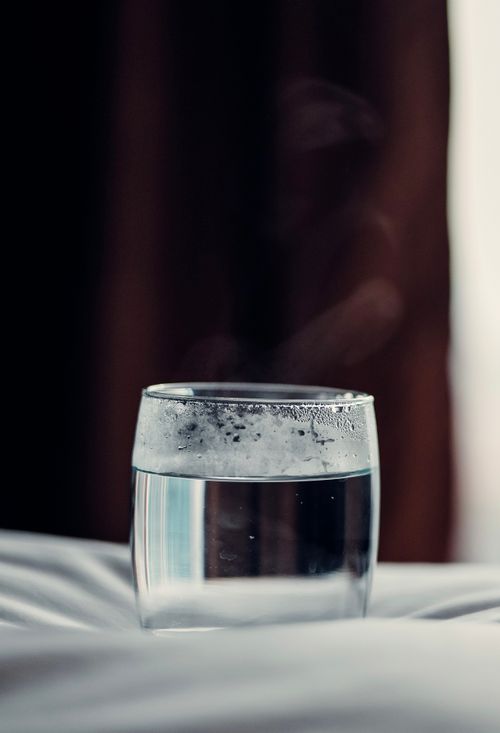 Free Close-up of a steaming glass of water on a fabric surface, creating a serene atmosphere. Stock Photo