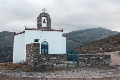Free A quaint small chapel in the Andros countryside surrounded by mountains. Stock Photo