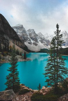 Breathtaking view of Moraine Lake with snow-capped peaks in Banff, Alberta. Ideal for winter nature photography.