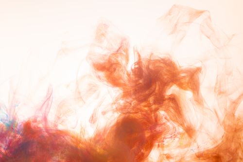 Free Captivating abstract art featuring vibrant orange and multicolor smoke swirls with a soft background. Stock Photo