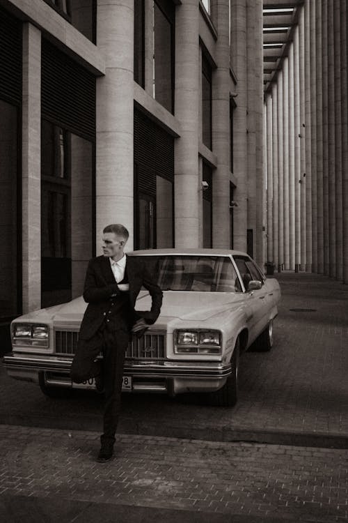 Man in Suit Leaning against Vintage Car 