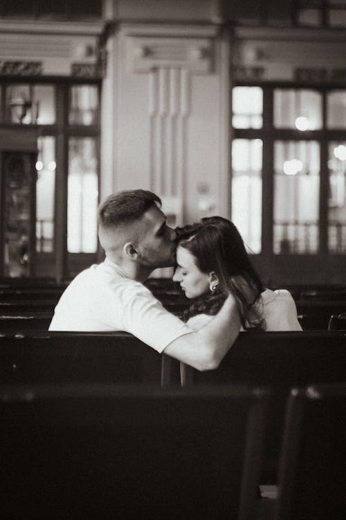 

A Grayscale of a Man Kissing a Woman on the Forehead