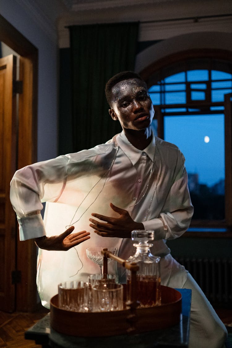 Stylish Young Man Posing Behind Tray Of Drinks At Night