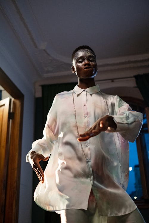 Low angle view of young man dancing in white shirt