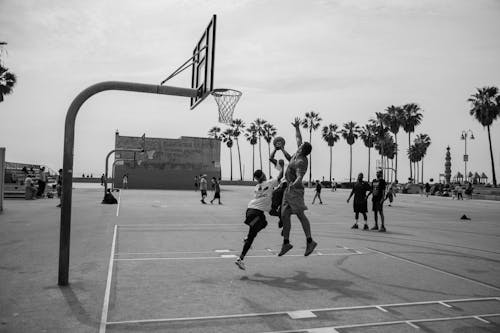 A Grayscale of Men Playing Basketball