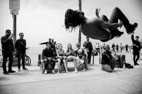 Free 

A Grayscale of People Watching a Shirtless Man do a Backflip Stock Photo