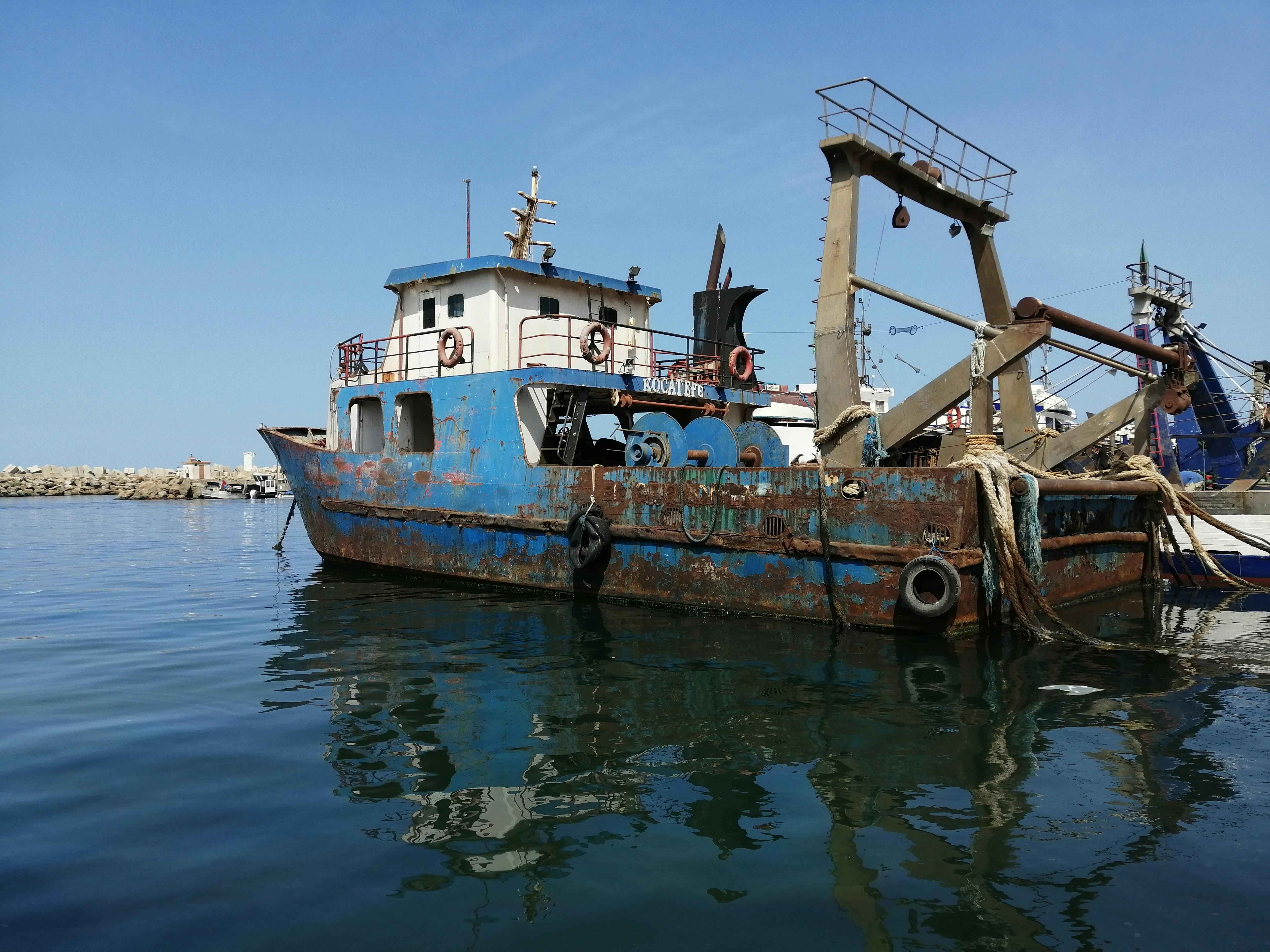 Rusty Fishing Boat Docked under a Blue Sky · Free Stock Photo