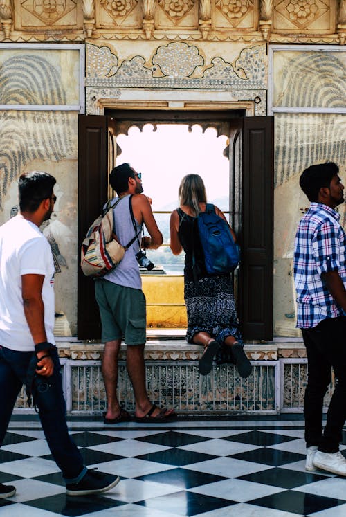 Photo of Man and Woman Looking at the Window