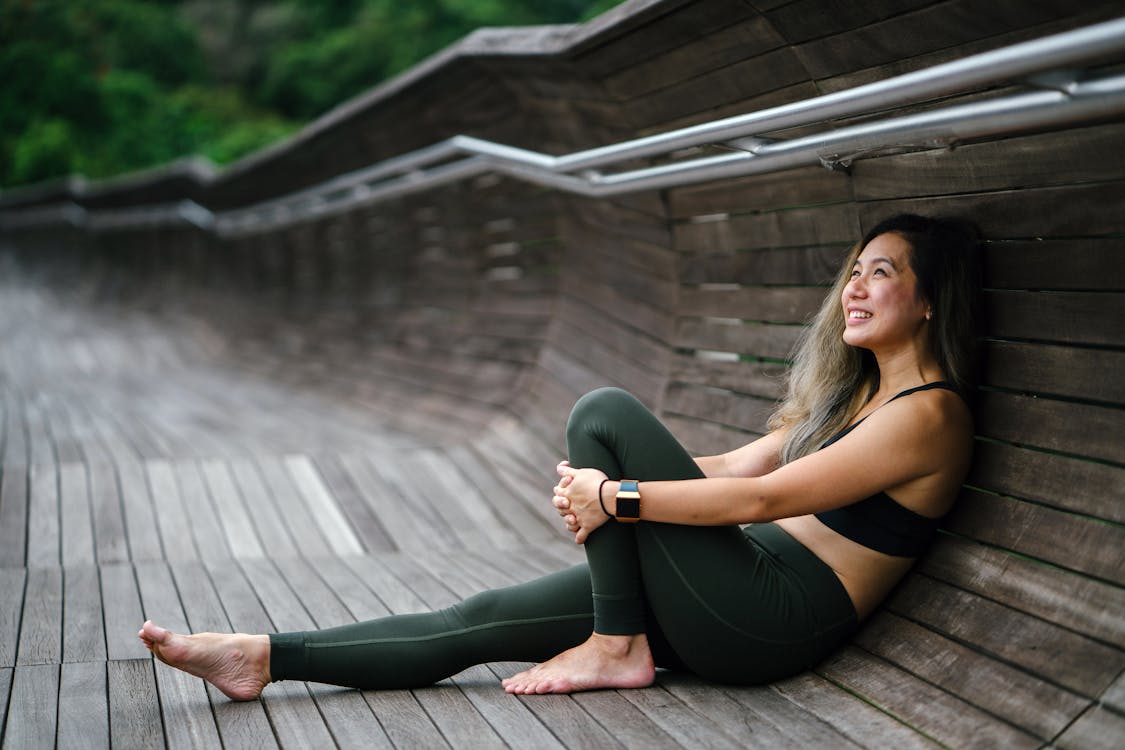 Photo of Smiling Woman Woman in Black Sports Bra and Black Leggings