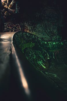 晚上拍摄的涂满涂鸦的黑暗滑板公园坡道