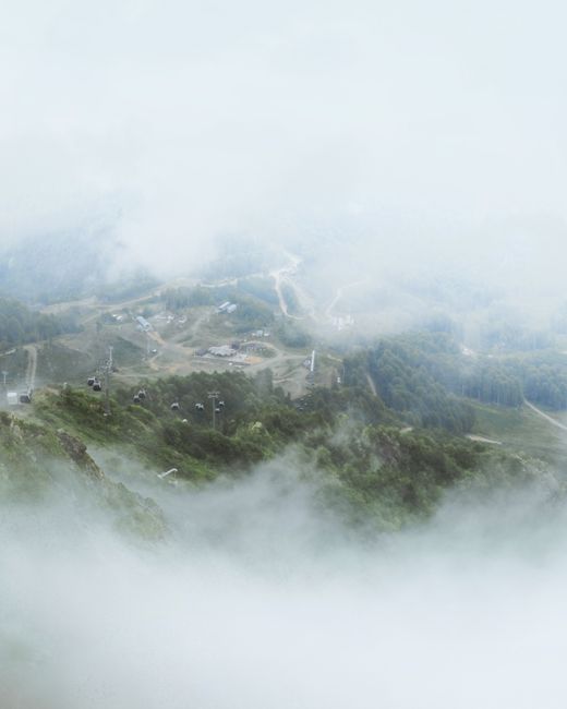 Aerial view of misty mountain landscape with cable cars in Krasnodar, Russia.