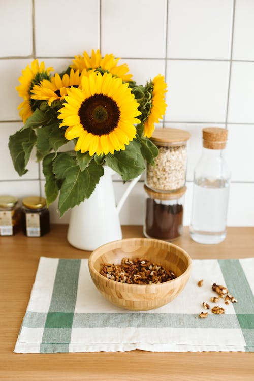 Free Bowl of Walnuts in front of Sunflowers Stock Photo