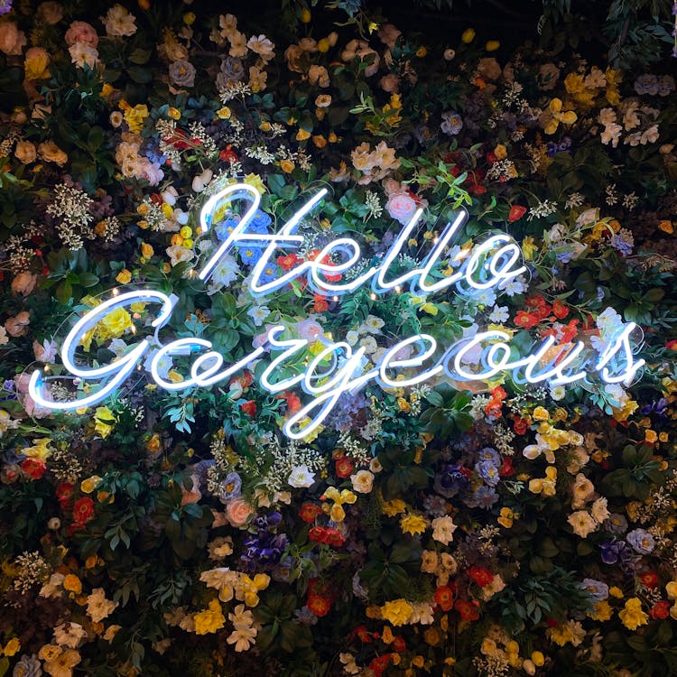 
A Neon Signage On A Floral Wall