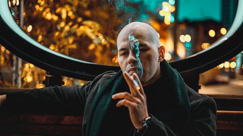 Man in Black Sweater Smoking Cigarette