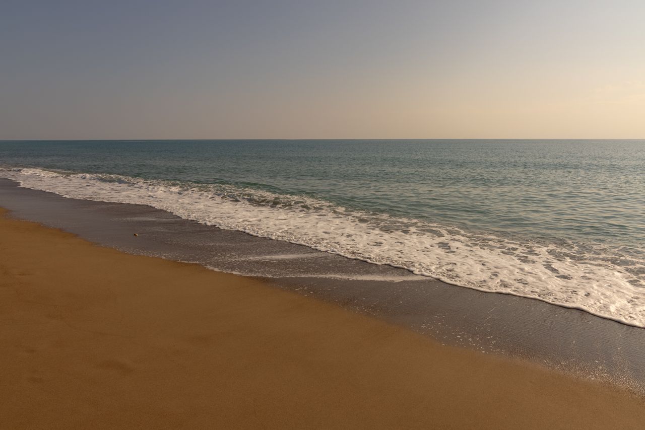 a peaceful beach scene with gentle waves lapping against a sandy shore