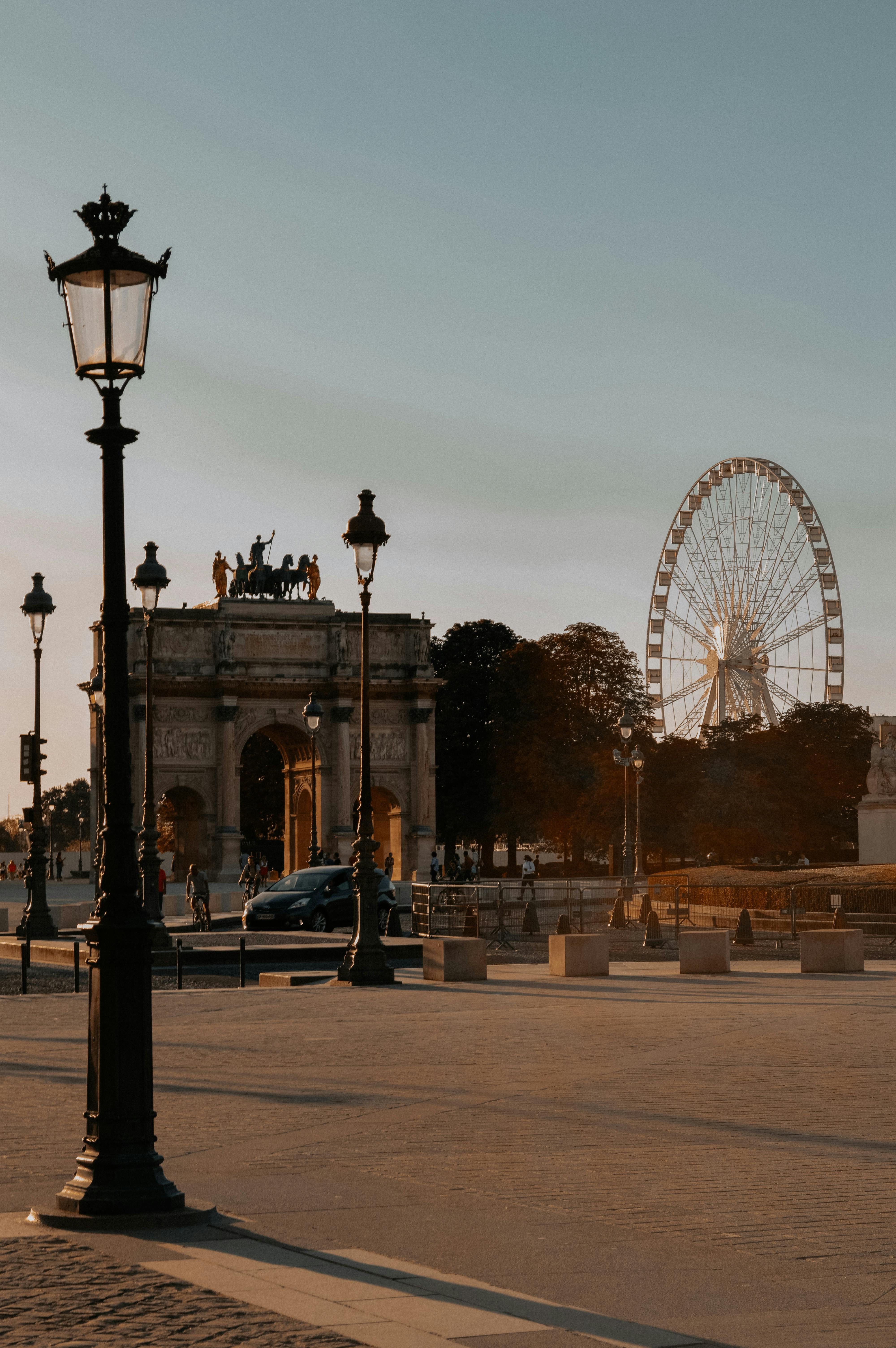 A scenic view of Place de la Concorde in Paris featuring a Ferris wheel and historical structures at sunset.