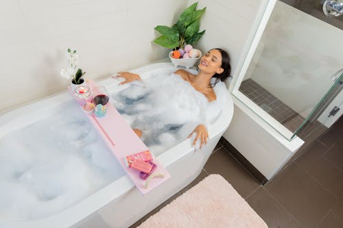Free Girl in White Bathtub With Pink and White Inflatable Toy Stock Photo